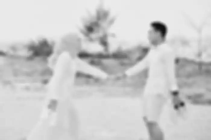 Ilustrasi foto prewedding. Demi mendapatkan foto aesthetic, pria ini bersembunyi di balik gaun panjang calon mempelai wanita.