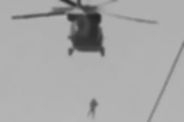 Seseorang yang terlihat digantung di bawah helikopter Black Hawk yang sedang dioperasikan oleh Taliban.