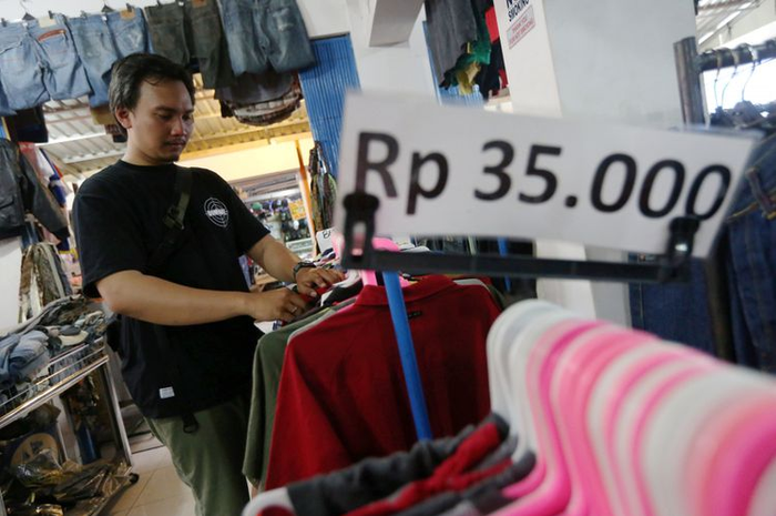 Seorang pengunjung sedang berburu baju bekas berharga murah di Pasar Poncol, Senen, Jakarta Pusat