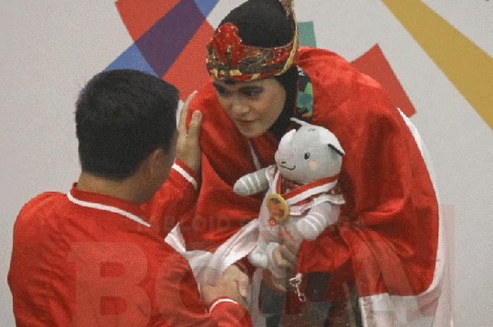 Menpora mengalungkan medali emas kepada atlet pencak silat Puspa Arumsari