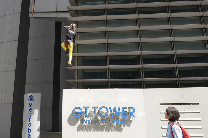Pemanjat gedung asal Perancis, Alain Robert, memanjat sisi GT Tower di Makati, Filipina, Selasa (29/1/2019). Pria dengan julukan 'Spider-Man' berusia 56 tahun itu kemudian ditangkap Kepolisian Kota Makati atas aksinya yang dinilai masuk ke properti orang lain tanpa izin atau menganggu publik.