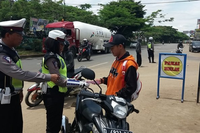  Polwan Satlantas Polres Sumedang tengah menindak pengguna sepeda motor yang tidak membawa kelengkapan surat-surat kendaraan bermotor dan perlengkapan kendaraan di Jalan Raya Bandung-Garut, Kecamatan Cimanggung, Kabupaten Sumedang, Jumat (18/11/2016).&nbsp;