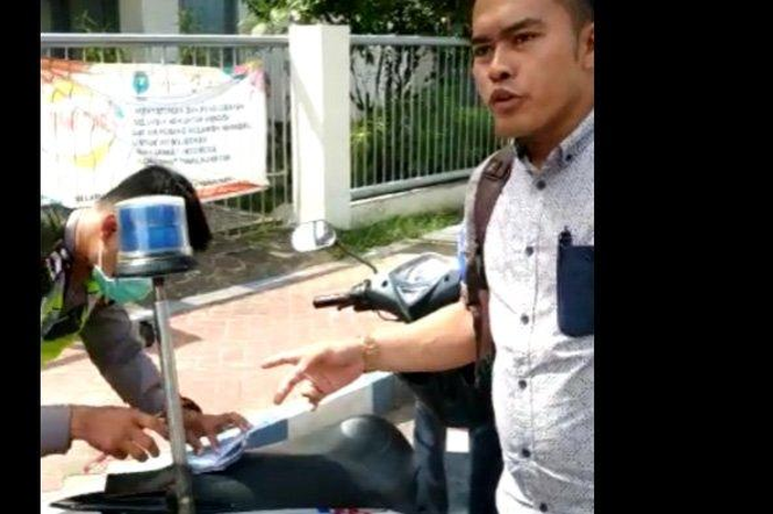 Oknum Satlantas Polres Sumenep saat menindak pelanggar lalulintas dengan diam-diam di Jalan Trunojoyo, Sumenep.&nbsp;