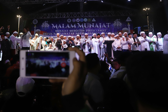 Jemaah Munajat 212 saat melaksanakan kegiatan sholawat dan dzikir nasional Aksi Malam Munajat 212 di Monas, Jakarta Pusat, Kamis (21/2/2019). Kegiatan Munajat 212 dan zikir bersama tersebut bertujuan untuk mempererat persatuan semua elemen bangsa Indonesia. (Tribunnews/Jeprima)