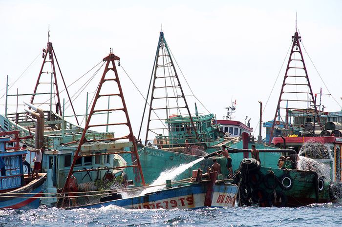 Sejumlah anak buah kapal bantu menyemprotkan air menggunakan mesin pompa ke dalam kapal nelayan Vietnam saat penenggelaman di Pulau Datuk, Kabupaten Mempawah, Kalimantan Barat, Sabtu (4/5/2019). Kementerian Kelautan dan Perikanan menenggelamkan 13 dari 51 kapal nelayan asing asal Vietnam.