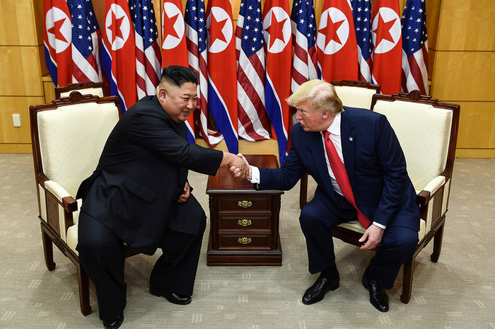 Pemimpin Korea Utara Kim Jong Un (kiri) dan Presiden AS Donald Trump berjabat tangan dalam sebuah pertemuan di wilayah keamanan bersama (JSA) Panmunjom di zona demiliterisasi (DMZ) Korea, Minggu (30/6/2019). Kedatangan Trump ke zona demiliterisasi Korea awalnya diagendakan untuk pertemuan dengan Pre