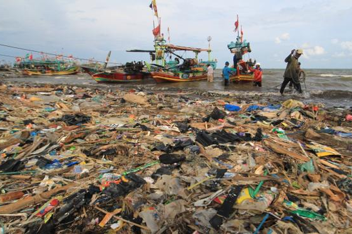 Nelayan menyandarkan perahunya di bibir pantai yang dipenuhi sampah plastik di Desa Dadap, Indramayu, Jawa Barat, Senin (26/11). ANTARA FOTO/Dedhez Anggara