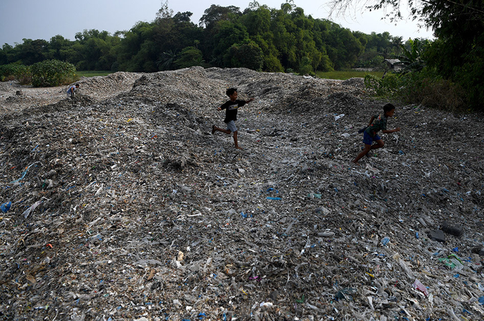 Sejumlah anak berlarian di tumpukan sampah plastik impor di Desa Bangun di Mojokerto, Jawa Timur, Rabu (19/6/2019). Berdasarkan data Lembaga Kajian Ekologi dan Konservasi Lahan Basah Ecoton, masuknya sampah dengan merk dan lokasi jual di luar Indonesia, diduga akibat kebijakan China menghentikan imp