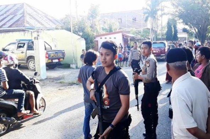 Polisi berjaga di rumah pelaku yang nyaris diamuk warga pasca penangkapan, Sabtu (27/07/2019).