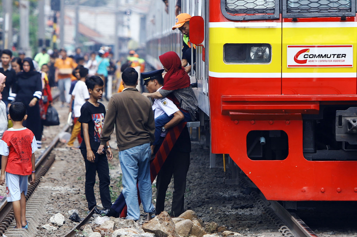 Penumpang terpaksa turun dari kereta rel listrik (KRL) yang berhenti di perlintasan Bukit Duri Jakarta Selatan, akibat padamnya listrik, Minggu (4/8/2019). Aliran listrik di Banten, Jabodetabek hingga Bandung terputus akibat adanya gangguan pada sejumlah pembangkit di Jawa. TRIBUNNEWS/HERUDIN 
