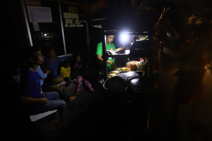 Warga beraktifitas menggunakan penerangan lilin dan lampu darurat, di wilayah Karet Tengsin Jakarta, Minggu malam (4/8/2019). Aliran listrik di Banten, Jabodetabek hingga Bandung terputus akibat adanya gangguan pada sejumlah pembangkit di Jawa. TRIBUNNEWS/HERUDIN 