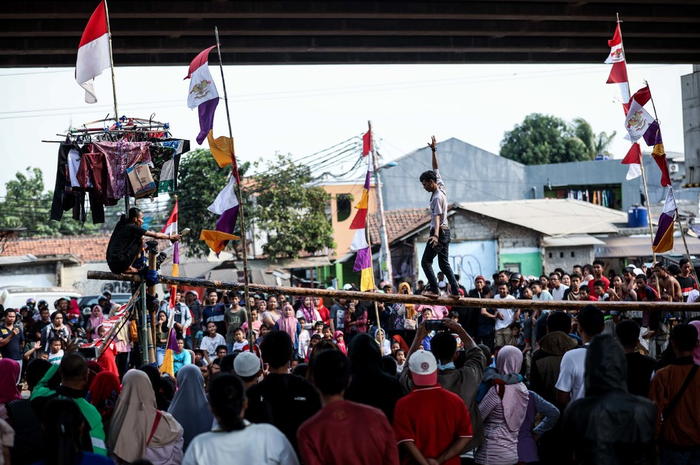 Warga mengikuti lomba panjat pinang, pukul bantal dan makan donat untuk memeriahkan HUT ke-74 Kemerdekaan RI di saluran Kalimalang, Jakarta Timur, Sabtu (17/8/2019).