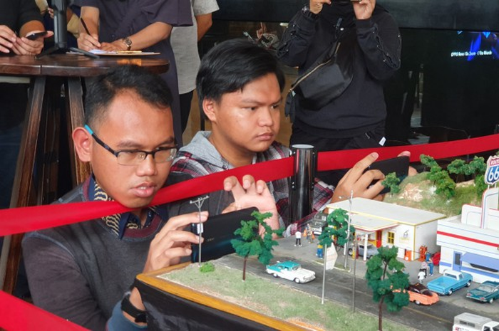 Orang-orang mencoba memotret mainan menggunakan fitur canggih yang ada di Oppo Reno 10x Zoom.