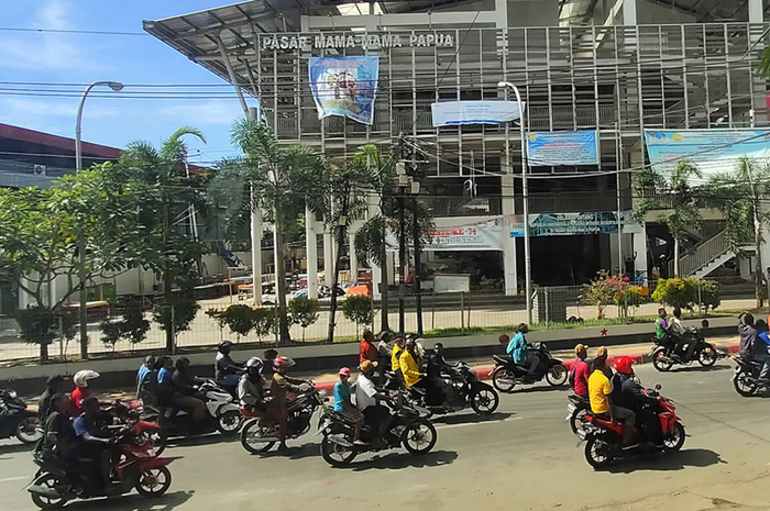 Sejumlah warga mengendarai kendaraan melintasi Pasar Mama Mama Papua seusai aksi unjuk rasa di Jayapura, Papua, Jumat (30/8/2019). Sejumlah bangunan dan kendaraan terbakar saat aksi unjuk rasa yang berakhir rusuh di Jayapura, Kamis kemarin, masih terkait memprotes dugaan tindak rasisme kepada mahasi