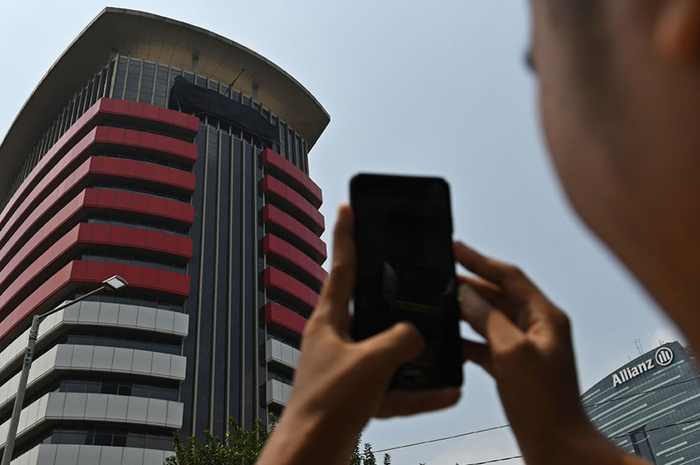 Warga memotret tulisan Komisi Pemberantasan Korupsi (KPK) yang tertutup kain hitam di Gedung Merah Putih KPK, Jakarta, Senin (9/9/2019). Penutupan tulisan KPK dengan kain hitam yang dilakukan sejak Minggu (8/9/2019) itu merupakan bagian dari aksi simbolis jajaran pimpinan hingga pegawai KPK jika rev
