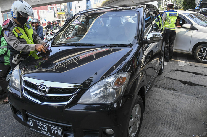 Petugas kepolisian menghentikan mobil berplat nomor genap yang memasuki Jalan Salemba Raya, di Matraman, Jakarta, Senin (9/9/2019). Petugas kepolisian mulai memberlakukan penindakan berupa tilang terhadap pengendara mobil yang melanggar di kawasan perluasan sistem ganjil-genap. ANTARA FOTO/Galih Pra