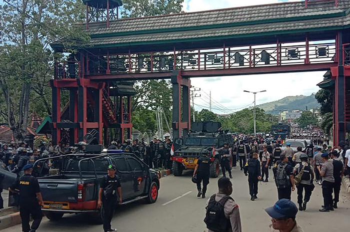 Sejumlah personel polisi berjaga di sebuah universitas di Jayapura, Papua, menyusul kerusuhan yang terjadi, Senin (23/9/2019) siang. Gubernur Papua Lukas Enembe menyebut terdapat korban jiwa dan luka-luka dari kerusuhan yang masih ditelusuri penyebabnya tersebut.
