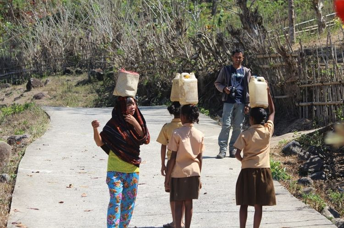 Siswa-siswi SDI Tuanio, Desa Pagomogo, Kecamatan Nangaroro, Kabupaten Nagekeo, Flores, NTT memikul air ke sekolah, Senin (14/10/2019).