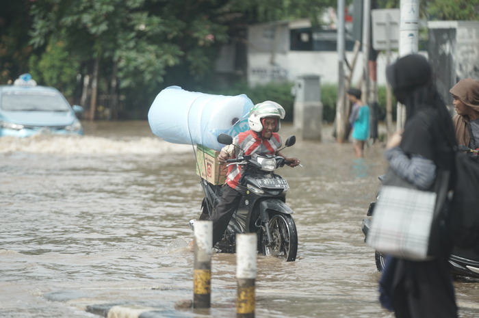 Pemotor menerjang banjir di Green Garden, Kedoya, Jakarta Barat