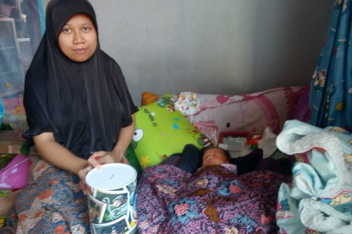 Riska (27) bersama bayinya, yang baru berumur sepekan di rumahnya di Desa Rahong, Cianjur, Jawa Barat, Jumat (17/01/2020). Riska membayar biaya persalinan anak pertamanya itu menggunakan uang koin pecahan Rp1.000 