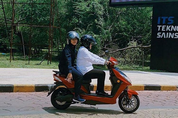 Wali Kota Surabaya Tri Rismaharini membonceng ajudannya mengendarai sepeda motor listrik merek U-Winfly warna merah hitam di Institut Teknologi 10 November (ITS), Surabaya, Jawa Timur, Selasa (25/2/2020). 