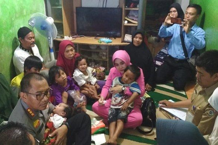 Kapolresta Balikpapan Kombes Pol Turmudi beserta Isinya Ny Tina Turmudi menggendong Balita yatim piatu berusia 1 Bulan 7 Hari di rumah neneknya di RT 20, Kelurahan Sepinggan Raya Kecamatan Balikpapan Selatan.