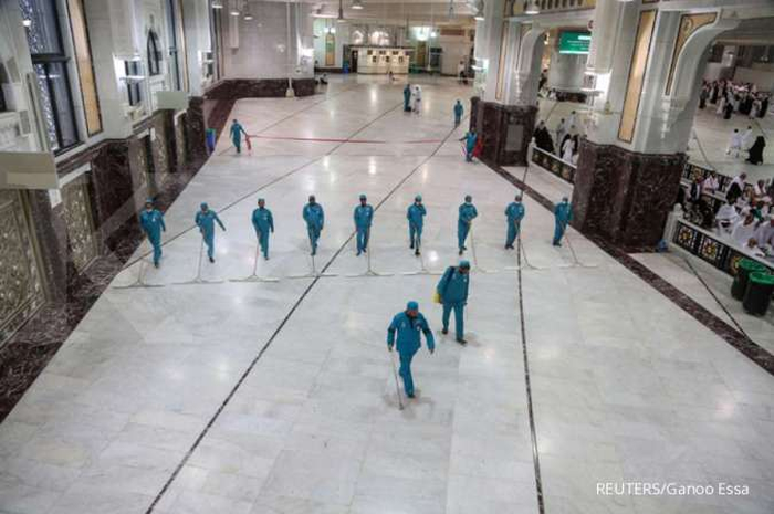 ILUSTRASI. Petugas bermasker membersihkan Masjidil Haram.