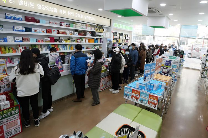Antrean di sebuah apotek di Korea Selatan, saat virus corona mewabah dan ditetapkan WHO sebagai pandemi. Gambar diambil pada Minggu (15/3/2020).