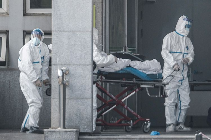 Petugas medis membawa seorang pasien yang diduga terinfeksi virus misterius mirip SARS, ke rumah sakit Jinyintan, di Kota Wuhan, China, Sabtu (18/1/2020).