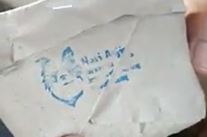 Nasi bungkus yang terdapat logo kepala anjing dan tulisan nasi anjing