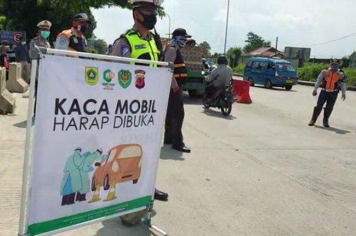 Petugas gabungan mengawasi pengendara yang melintas di check point PSBB Kabupaten Bogor di Cigombong yang berbatasan dengan Cicurug, Kabupaten Sukabumi, Rabu (29/4/2020).  