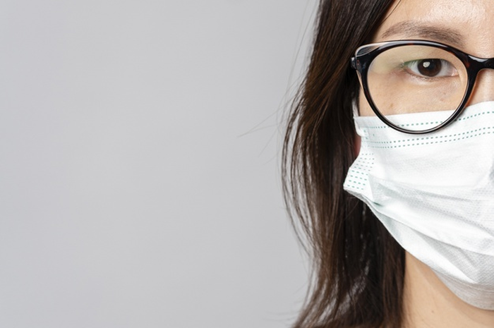Ilustrasi perempuan berkacamata memakai masker