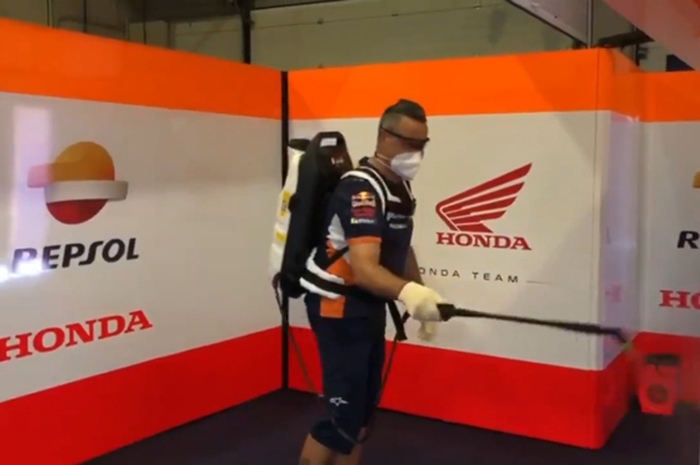 Juanito, salah seorang kru Repsol Honda Team, jadi punya kerjaan baru sebagai penyemport disinfektan paddock tim. Wujud protokol kesehatan di MotoGP 2020 benar-benar diprioritaskan
