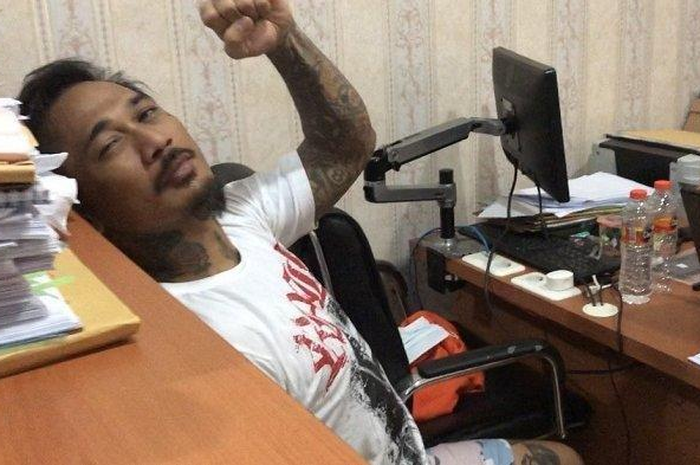 Jerinx mengepalkan tangan kiri sebelum menjalani pemeriksaan di Polda Bali. Jerinx diperiksa terkait kasus yang menjeratnya, Selasa (18/8/2020). 