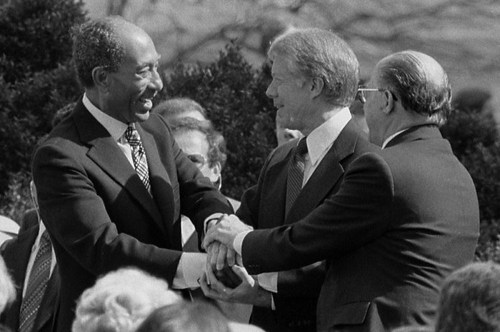 Presiden Mesir Anwar Sadat, Presiden AS Jimmy Carter, dan PM Israel Menachem Begin bersalaman usai meneken perjanjian damai di Gedung Putih, Washington DC.