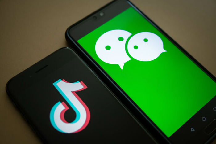 The logo for Tencent Holdings Ltd.'s WeChat app, right, and the logo for ByteDance Ltd.'s TikTok app are arranged for a photograph on smartphones in Hong Kong, China, on Friday, Aug. 7, 2020. President Donald Trump signed a pair of executive orders prohibiting U.S. residents from doing business with