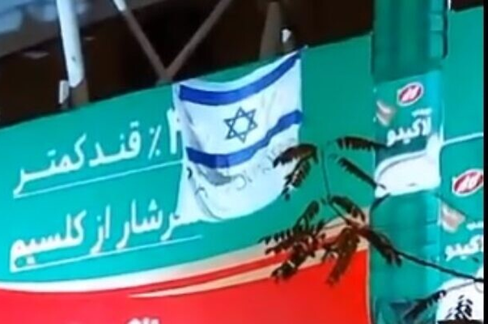 Bendera Israel dan tanda bertuliskan 'Terima kasih, Mossad' di pinggiran kota Teheran