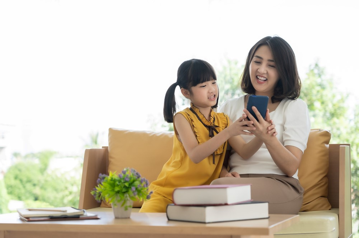 ilustrasi anak dan ibu sedanng memperhatikan ponsel