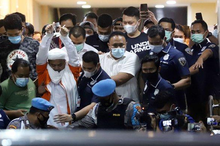 Pemimpin Front Pembela Islam (FPI) Muhammad Rizieq Shihab mengenakan baju tahanan seusai menjalani pemeriksaan di Polda Metro Jaya, Jakarta Pusat, Minggu (13/12/2020) dini hari. 