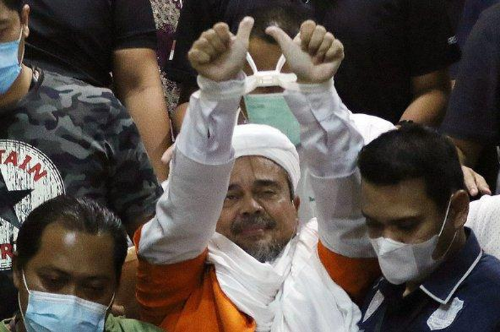 Pemimpin Front Pembela Islam (FPI) Muhammad Rizieq Shihab mengenakan baju tahanan seusai menjalani pemeriksaan di Polda Metro Jaya, Jakarta Pusat, Minggu (13/12/2020) dini hari. 