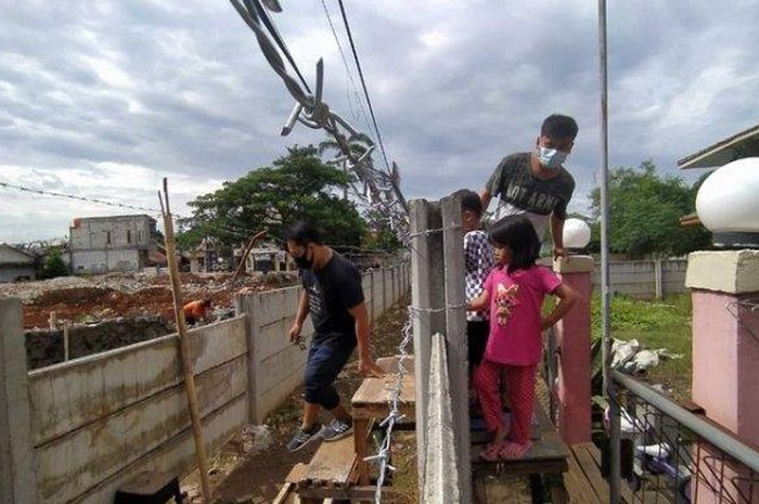 Anton dan keluarga mesti menggunakan kursi untuk keluar dari akses rumah yang ditemboki Ruli.