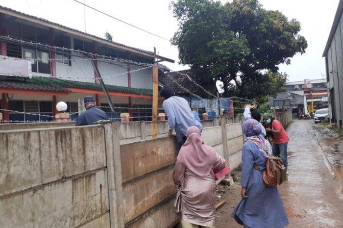 Kediaman Melinda di RT 04 / RW 03 Jalan Akasia, Kelurahan Tajur, Kecamatan Ciledug, Kota Tangerang dipagar tembok beton. Ruli yang membangun dinding tersebut mengurung rumah Melinda.  