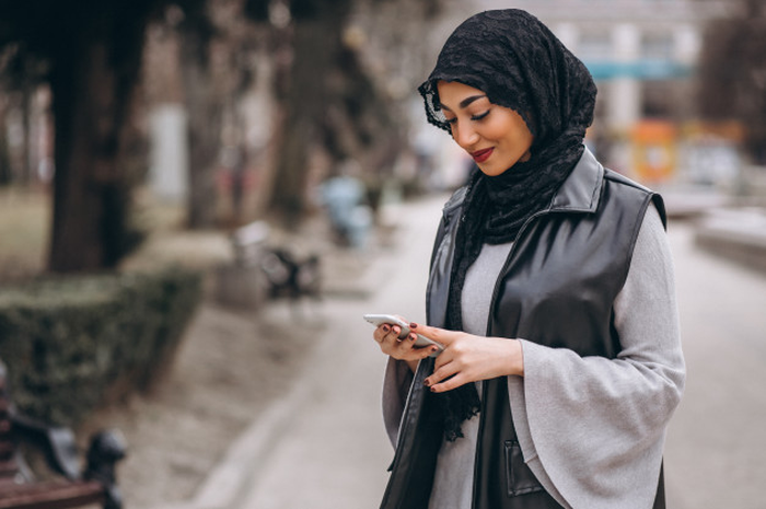 Ilustrasi wanita muslim menggunakan smartphone