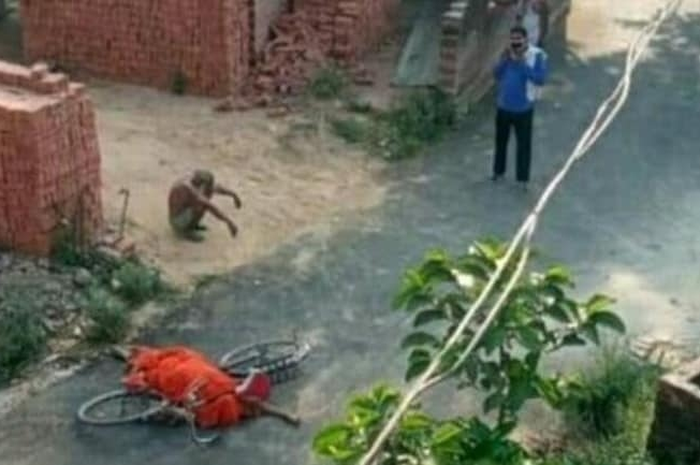 Pemandangan pilu di India seorang pria beristirahat saat mencari lokasi kremasi untuk jenazah istrinya yang ia letakkan di dekat sepedanya di pinggir jalan. India alami lonjakan kasus dengan catatan 117 korban meninggal Covid-19 per jam nya