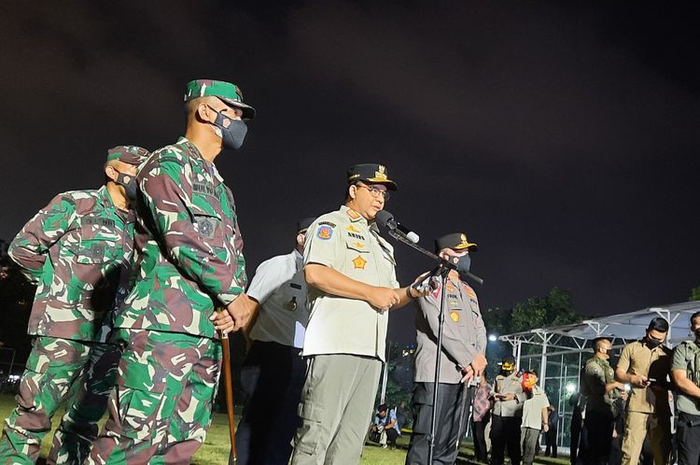 Anies Baswedan saat memimpin apel gabungan di lapangan Blok S, Kebayoran Baru, Jakarta Selatan pada Minggu (13/6/2021) malam.