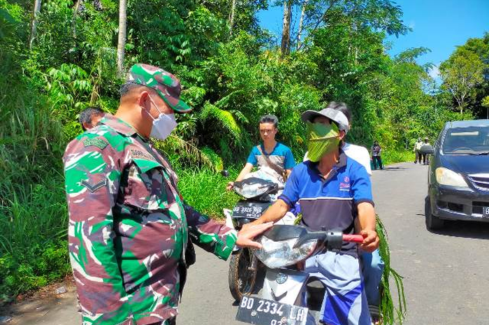 Panik melihat banyak petugas, petani ini membuat masker dadakan dari daun. 