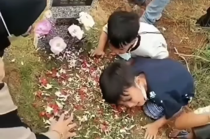 Potret 2 bocah ini bikin meleleh. Keduanya terus mengucapkan salam sembari menempelkan telinga di atas pusara ibunda. 
