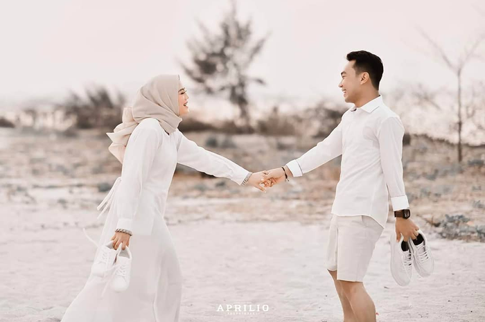 Ilustrasi foto prewedding. Demi mendapatkan foto aesthetic, pria ini bersembunyi di balik gaun panjang calon mempelai wanita.