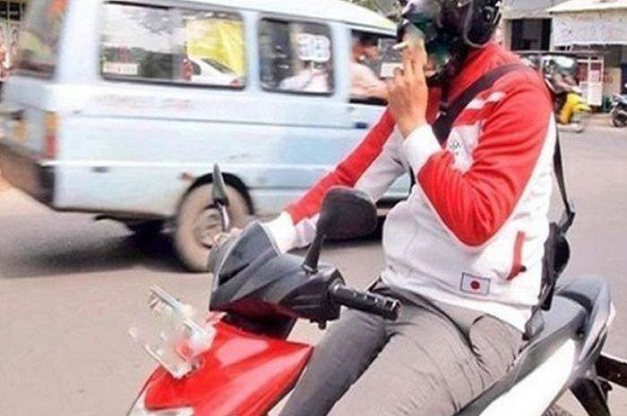 Ilustrasi naik motor sambil merokok