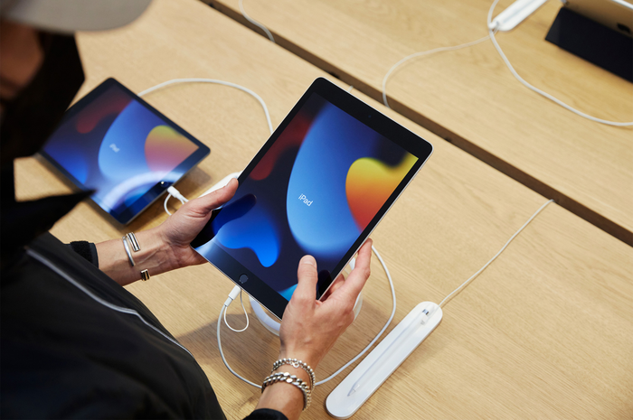 Pengunjung Apple Store mencoba mengoperasikan iPad 9